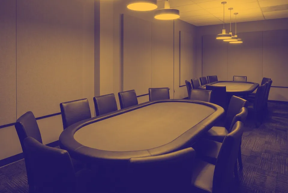 Two empty oval poker tables with chairs pushed in under pendant lights, shown in two colours.